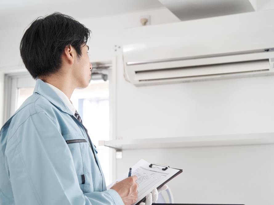 japanese male electrician checking home aircon